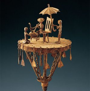 アセン”帽子をかぶった王にひざまづき貢物を献上する人と日傘を持つ従者